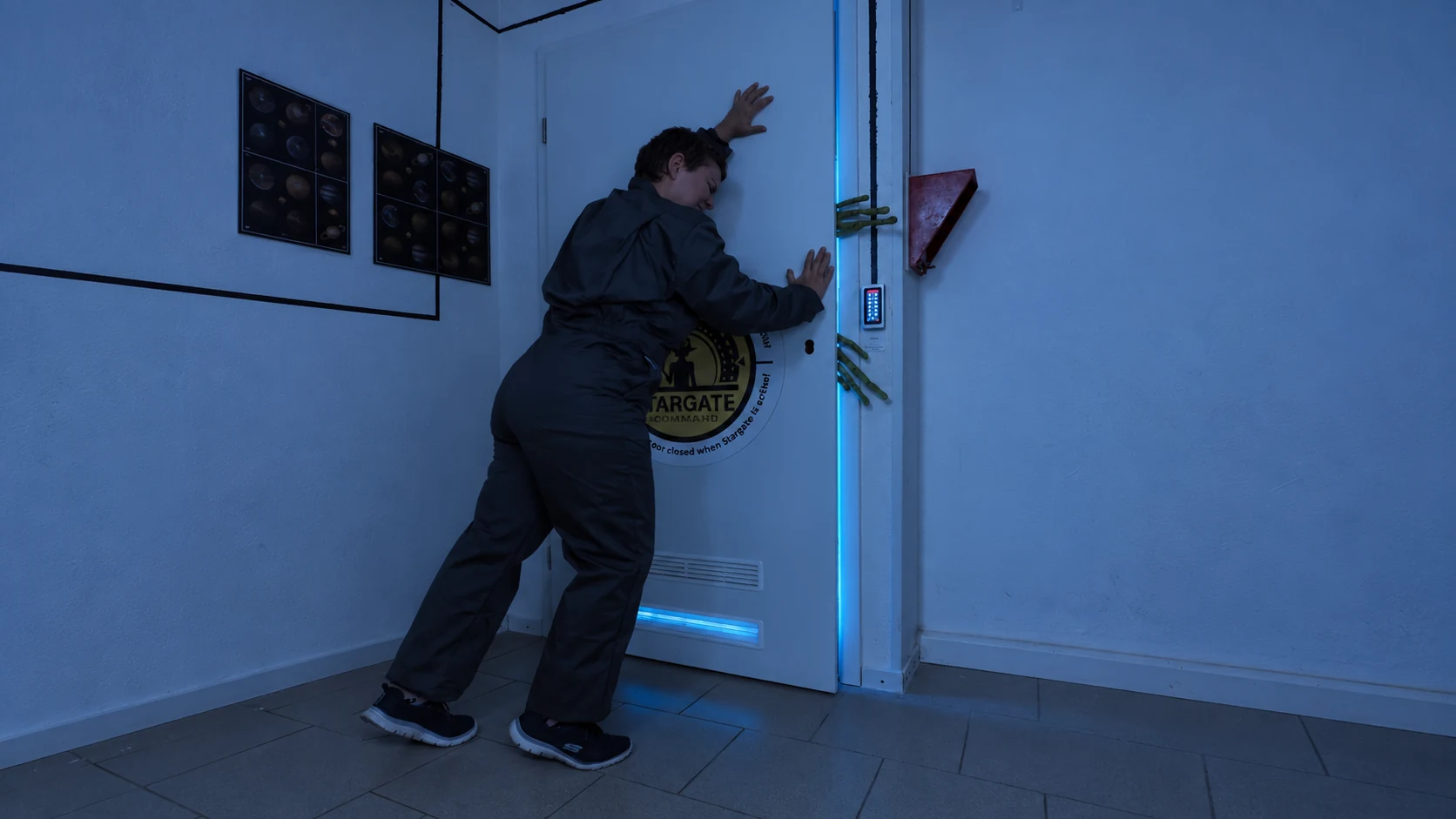Player at the blue-lit door with alien props